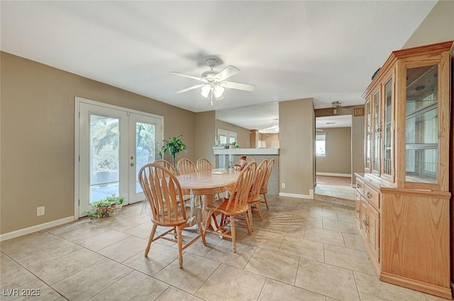 dining area with a wealth of natural light, ceiling fan, french doors, and light tile patterned floors