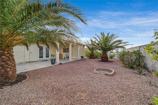 view of yard featuring a patio and french doors