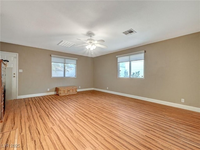 spare room featuring ceiling fan, plenty of natural light, and light hardwood / wood-style flooring