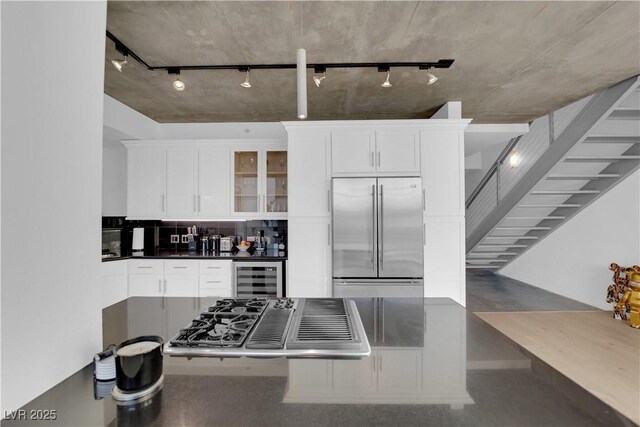 360 E Desert Inn Rd Unit 604, Las Vegas, NV 89109 - kitchen with stainless steel appliances, wine cooler, track lighting, and decorative backsplash