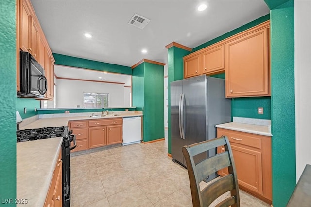 kitchen with sink, light tile patterned floors, light brown cabinets, and black appliances