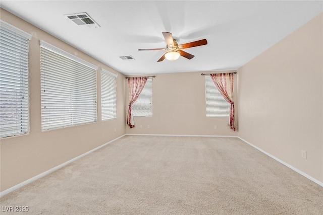 unfurnished room with light colored carpet and ceiling fan