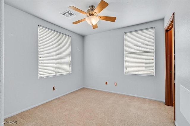 empty room featuring ceiling fan and light carpet