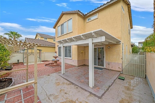 rear view of house featuring a pergola and a patio area