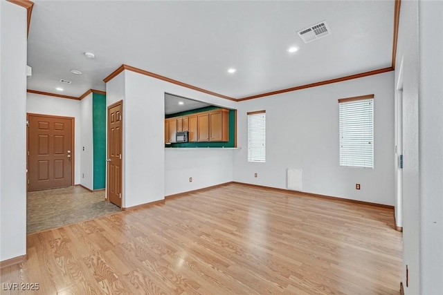 unfurnished living room with crown molding and light hardwood / wood-style flooring