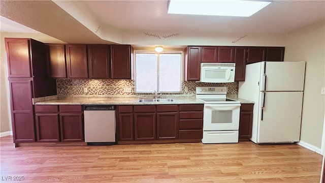 kitchen featuring white appliances, light wood-type flooring, sink, and backsplash