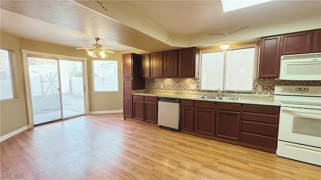 kitchen featuring light wood-type flooring, white appliances, sink, and tasteful backsplash