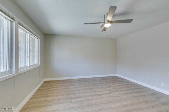 empty room featuring a ceiling fan, light wood-style flooring, and baseboards