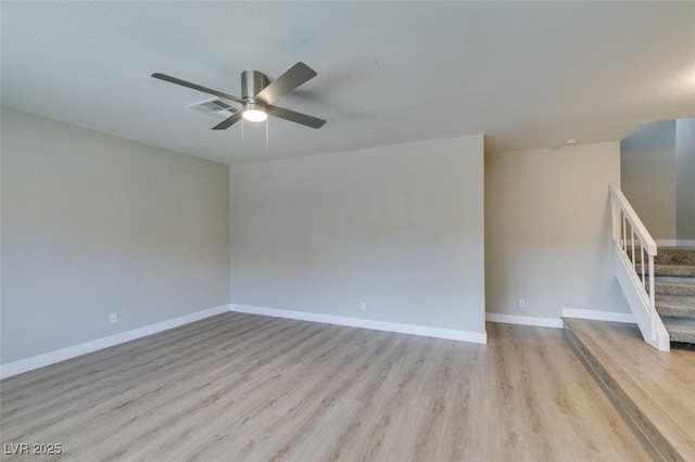 unfurnished room with light wood finished floors, visible vents, stairway, a ceiling fan, and baseboards