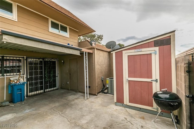 view of shed with cooling unit and fence