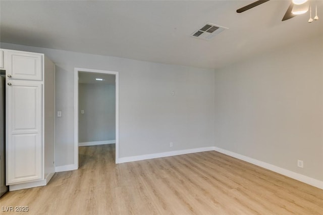 unfurnished room featuring baseboards, visible vents, ceiling fan, and light wood finished floors