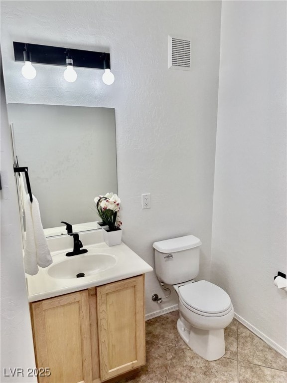 bathroom featuring vanity, tile patterned floors, and toilet