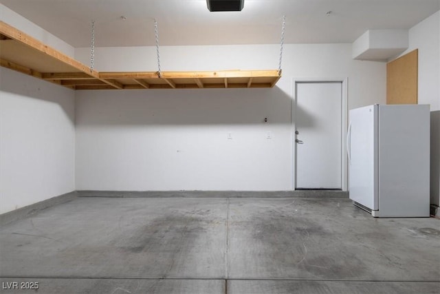 garage with a garage door opener and white refrigerator