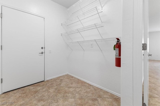 spacious closet with light tile patterned floors