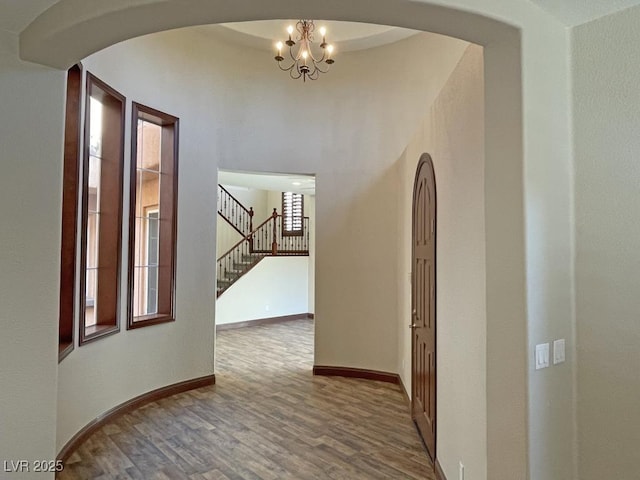 corridor featuring an inviting chandelier and hardwood / wood-style floors