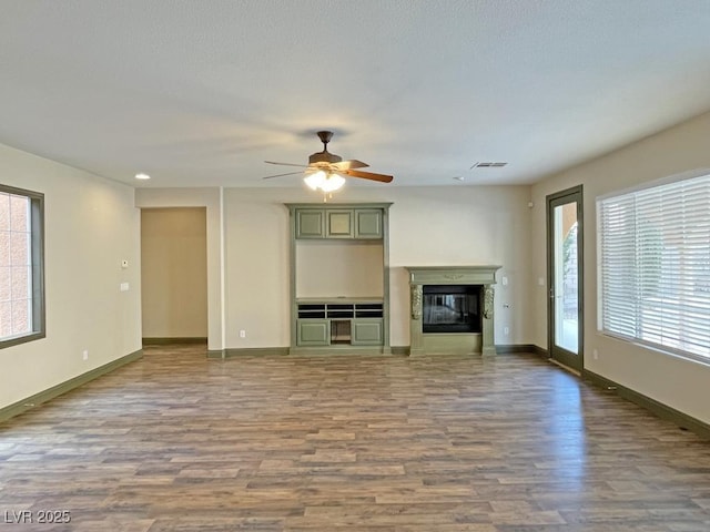 unfurnished living room with hardwood / wood-style flooring and ceiling fan