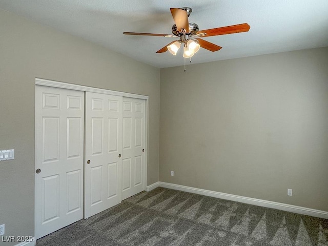 unfurnished bedroom with ceiling fan, dark carpet, and a closet