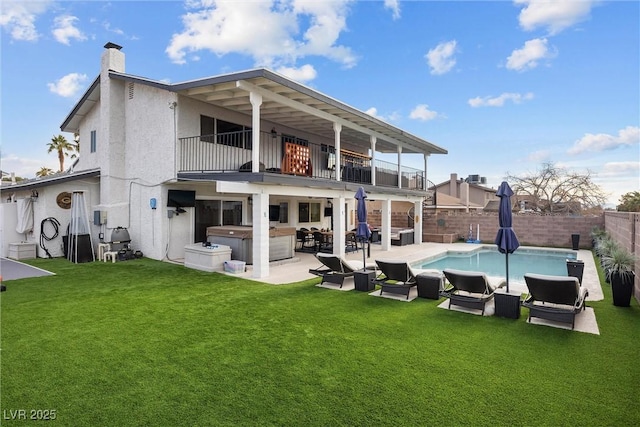 rear view of house with an outdoor living space, a balcony, a yard, a swimming pool with hot tub, and a patio