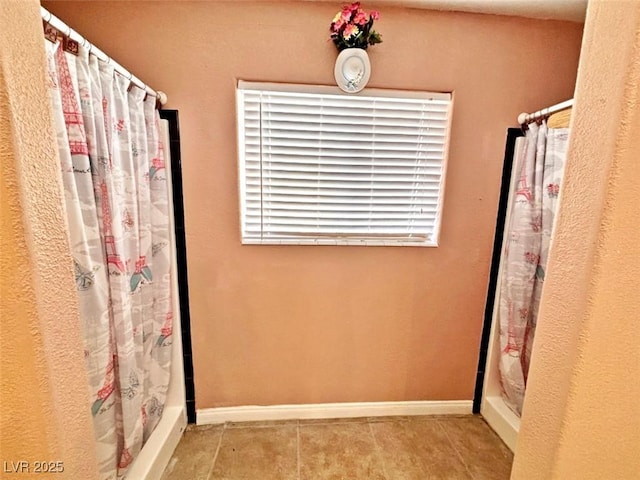 bathroom featuring curtained shower and tile patterned floors