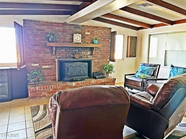 living room with beamed ceiling, a brick fireplace, and light tile patterned floors