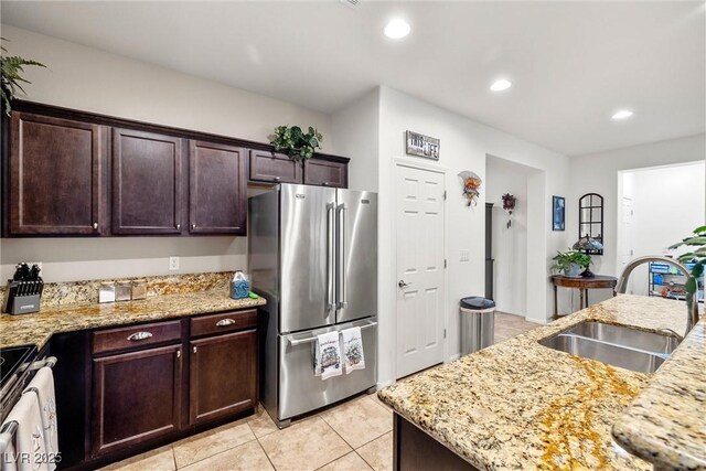 4459 Lavender, Pahrump, NV 89061 - kitchen with sink, light tile patterned floors, stainless steel appliances, dark brown cabinetry, and light stone countertops