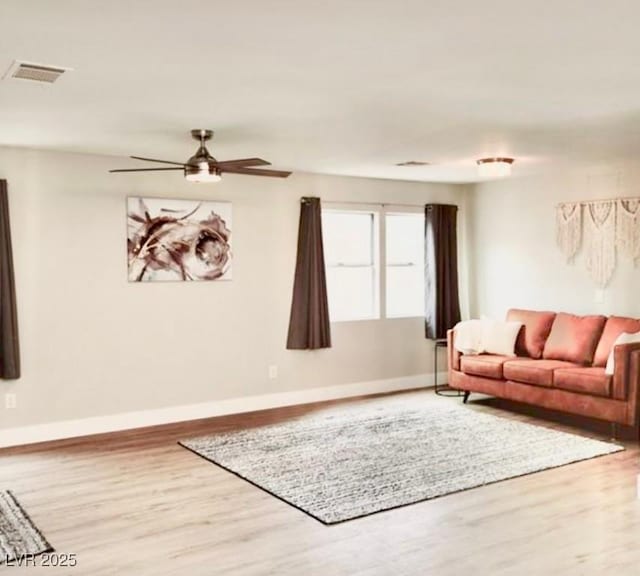 living room featuring hardwood / wood-style floors and ceiling fan