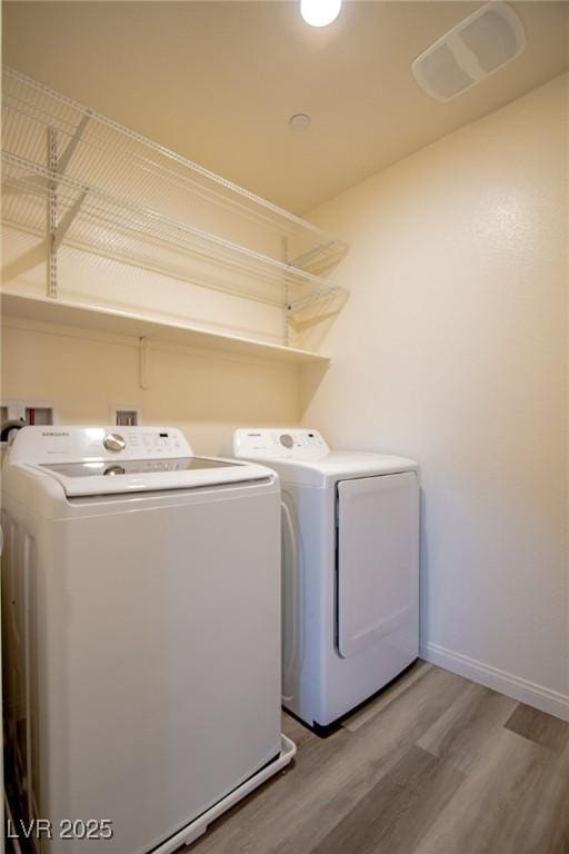 laundry area with washing machine and dryer and hardwood / wood-style floors