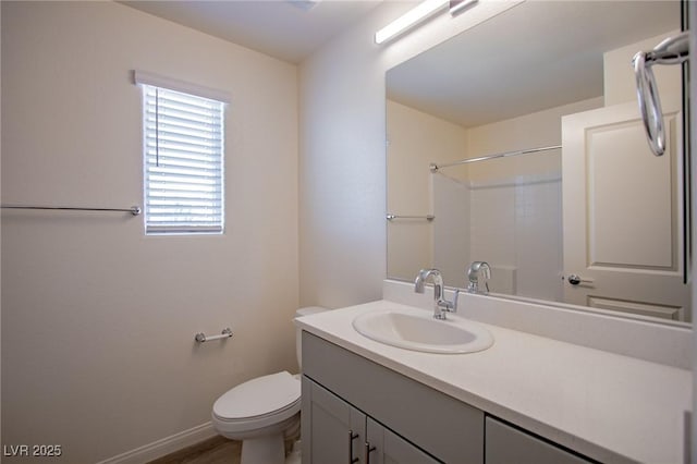 bathroom with vanity, toilet, and a shower