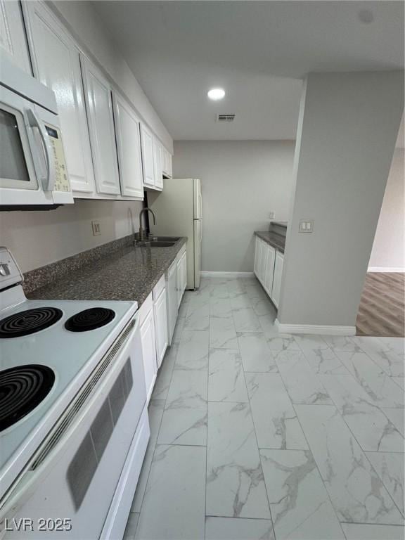 kitchen featuring white appliances, sink, and white cabinets