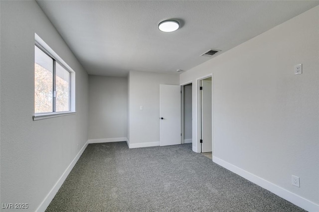 carpeted empty room with a textured ceiling