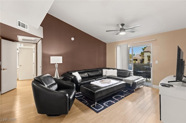 living room with ceiling fan, lofted ceiling, and light hardwood / wood-style flooring