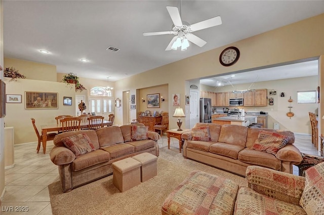 tiled living room featuring ceiling fan with notable chandelier