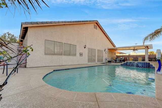 view of swimming pool with pool water feature, ceiling fan, and a patio area