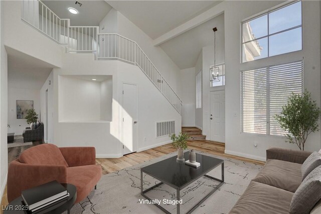 2573 Rafferty Creek Ln, Las Vegas, NV 89156 - living room with high vaulted ceiling, stairway, wood finished floors, baseboards, and healthy amount of natural light