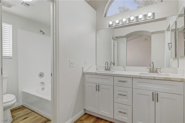 full bathroom featuring hardwood / wood-style floors, plenty of natural light, vanity, and toilet