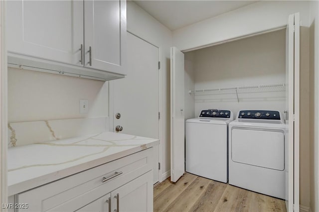 laundry room with light wood-type flooring and washer and dryer