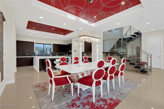 dining area with a notable chandelier and a tray ceiling