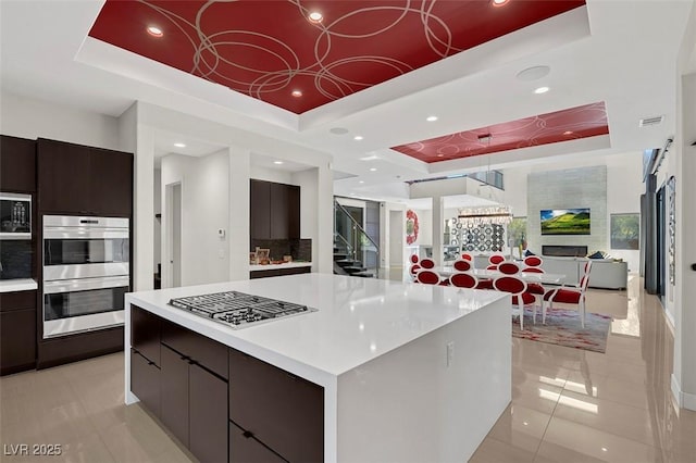 kitchen with a raised ceiling and a spacious island