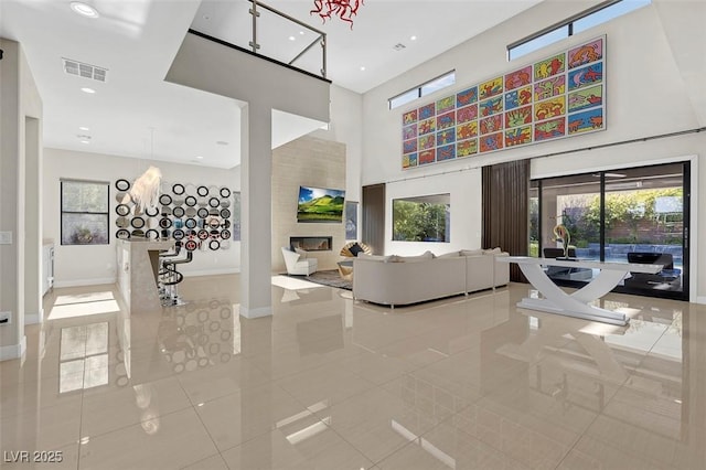 tiled living room featuring a high ceiling and a healthy amount of sunlight