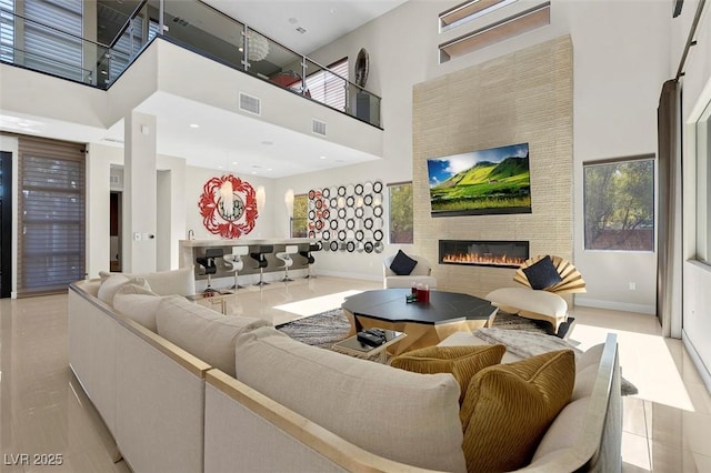 living room featuring plenty of natural light, light tile patterned floors, and a high ceiling