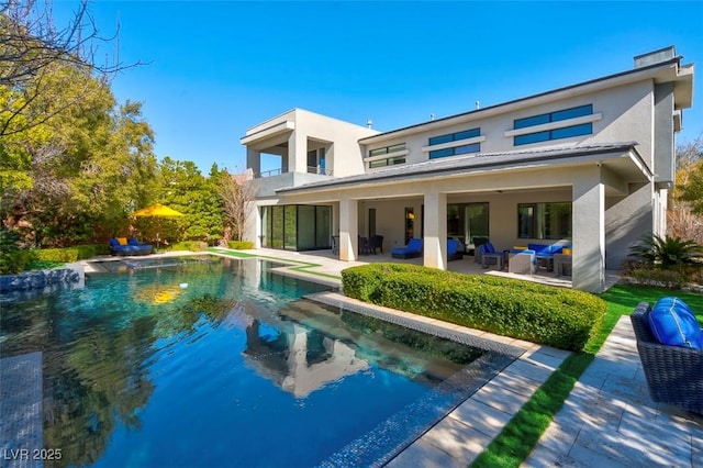 rear view of property with an outdoor living space and a patio