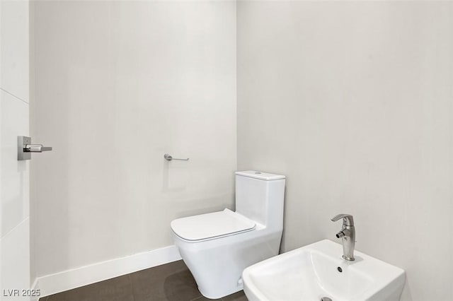 bathroom with a bidet, sink, tile patterned floors, and toilet