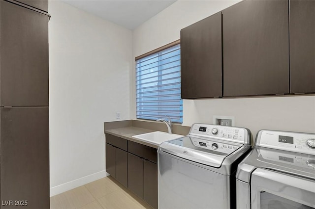 clothes washing area with cabinets, washer and dryer, sink, and light tile patterned floors