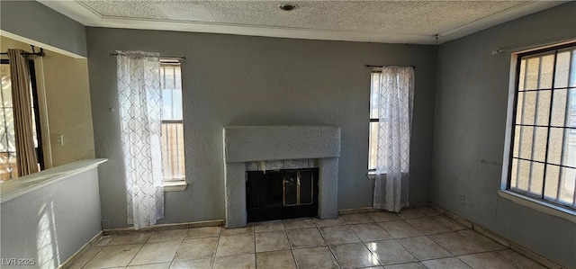 unfurnished living room with light tile patterned flooring, a healthy amount of sunlight, and a textured ceiling