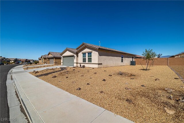 3924 E Garfield Dr, Pahrump, NV 89061 - view of front of home featuring stucco siding, a tile roof, fence, concrete driveway, and an attached garage