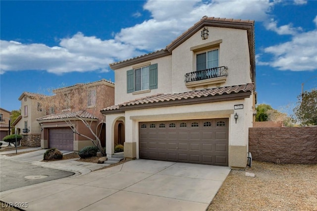 mediterranean / spanish house with a garage, a tile roof, concrete driveway, and stucco siding