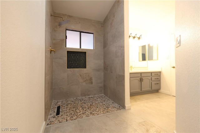 bathroom with vanity and a tile shower