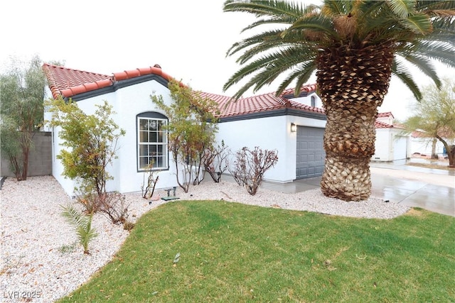 mediterranean / spanish-style home featuring a garage and a front lawn