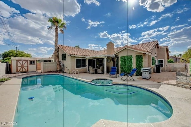 view of pool with an in ground hot tub, a storage shed, and a patio