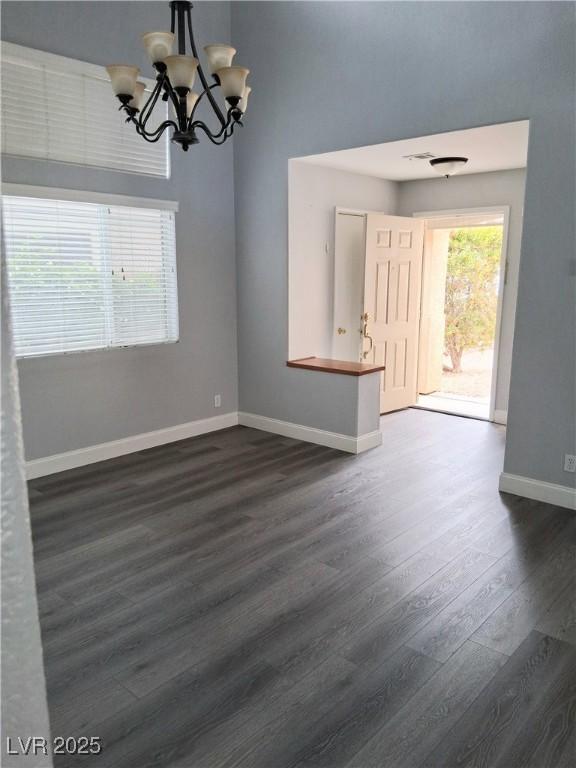 5830 Springmist St, North Las Vegas, NV 89031 - spare room with a chandelier, dark wood-style floors, and baseboards